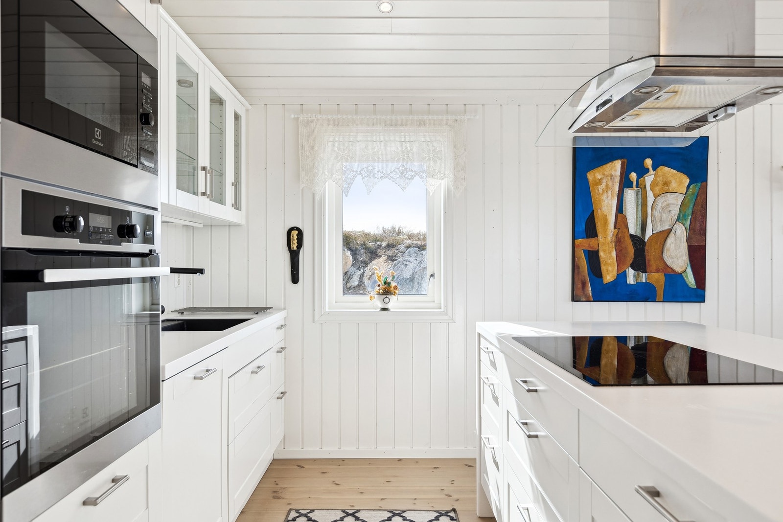 Kjøkkenet er lyst og moderne, med kjøkkenøy som gir ekstra benkeplass og en sosial sone Galleribilde