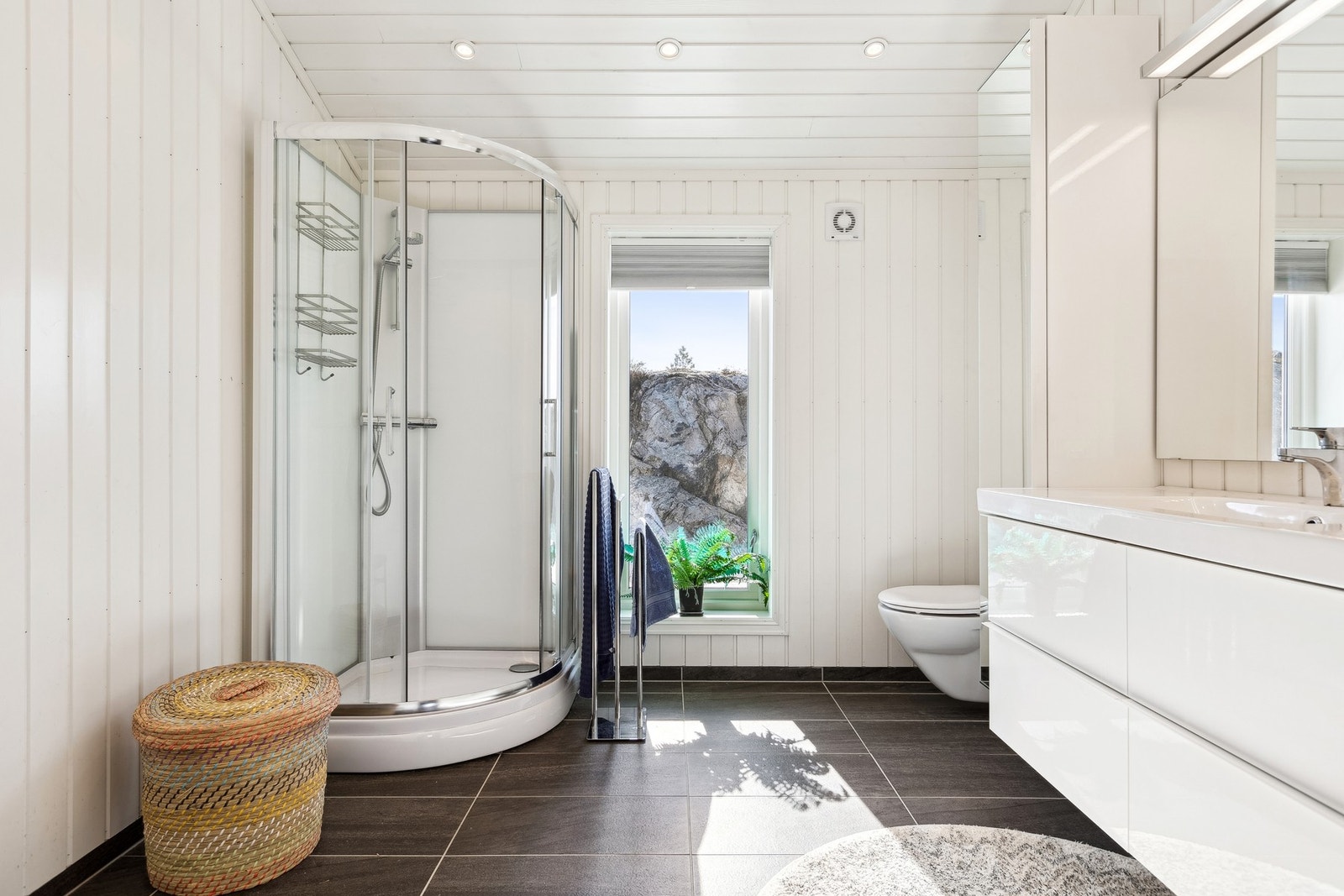 Lyst og tidløst baderom med flislagt gulv med gulvvarme. Galleribilde