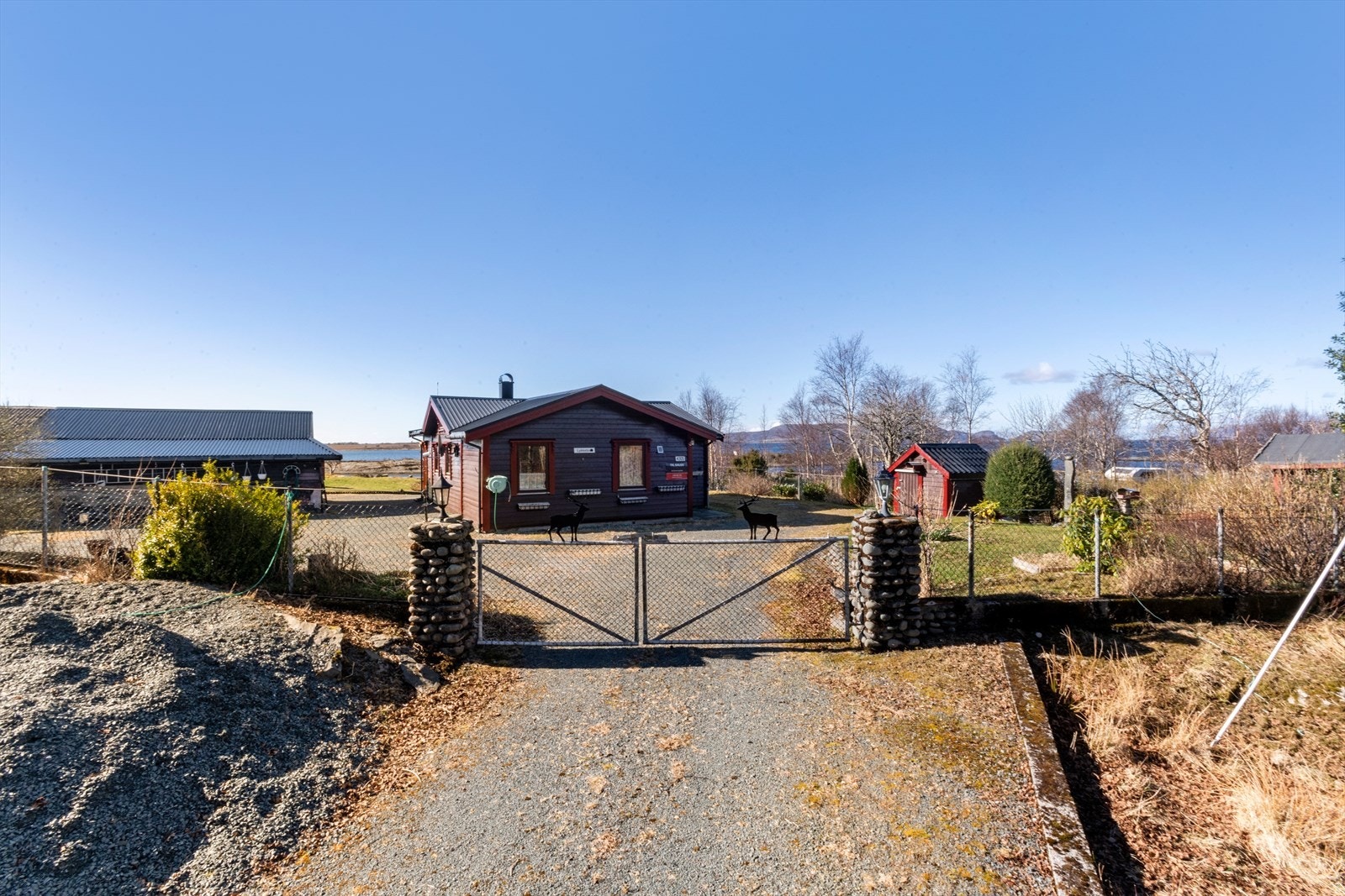 Tomten er relativt planert og pent opparbeidet med gruslagt innkjørsel med forstøtningsmur av naturstein som avgrenser innkjørsel og grønt arealet. Galleribilde