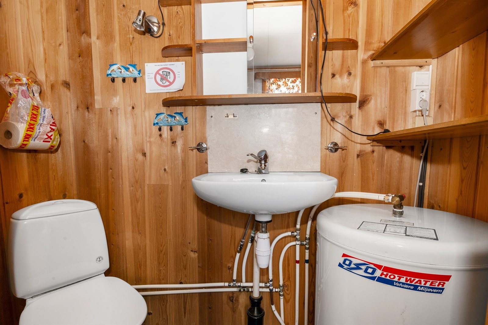 Toalettrom v/ vaskerom: Rom er utstyrt med 120L varmtvannsbereder, wc, vegghengt vask og speilskap, samt fastmonterte hyller. Rom har ikke sluk i gulv. Galleribilde