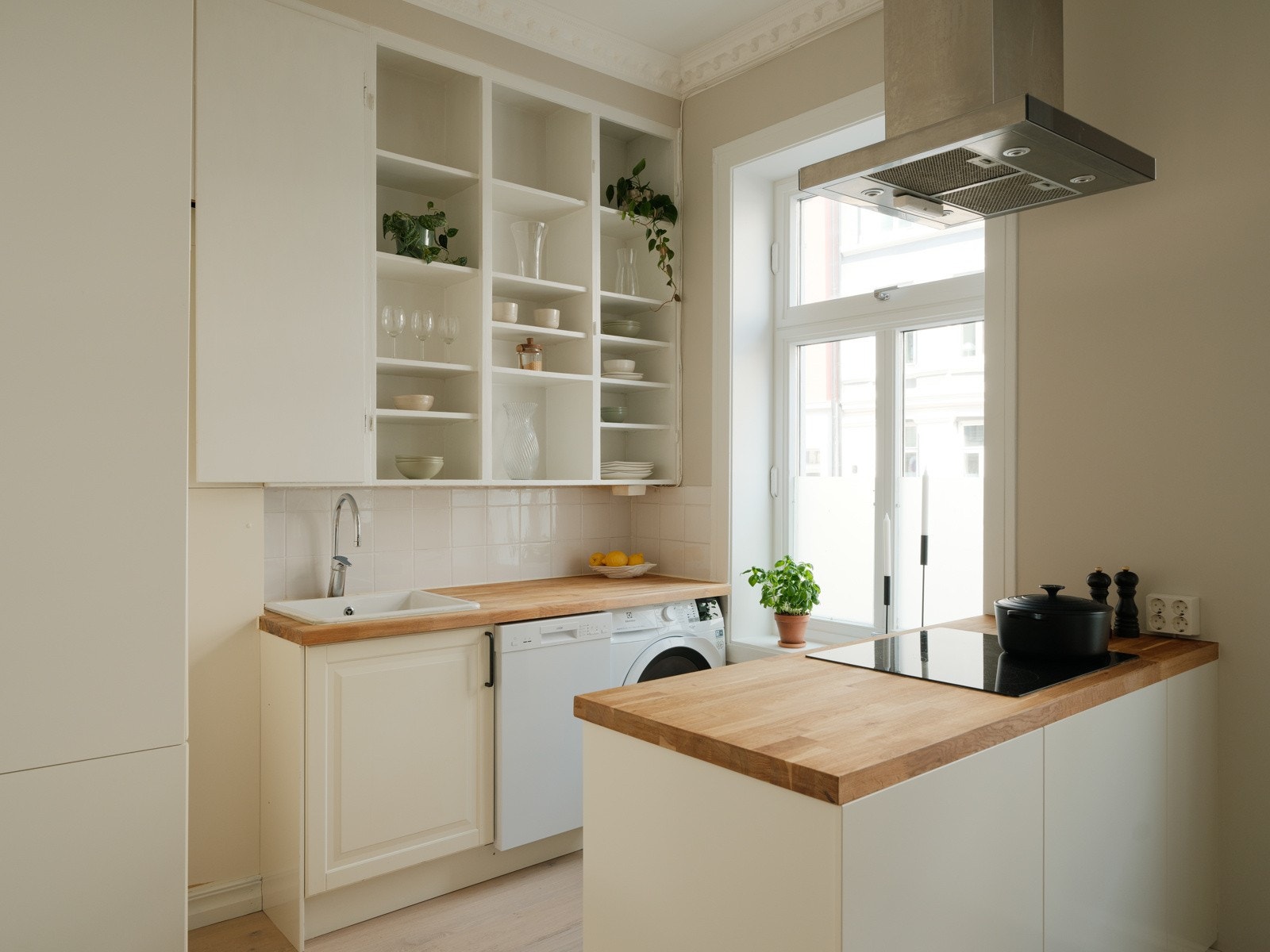 Kjøkkeninnredning med profilerte fronter, heltre benkeplate, fliser, oppvaskkum og ventilator. Integrert induksjonsplatetopp og stekeovn. Opplegg for vaskemaskin Galleribilde