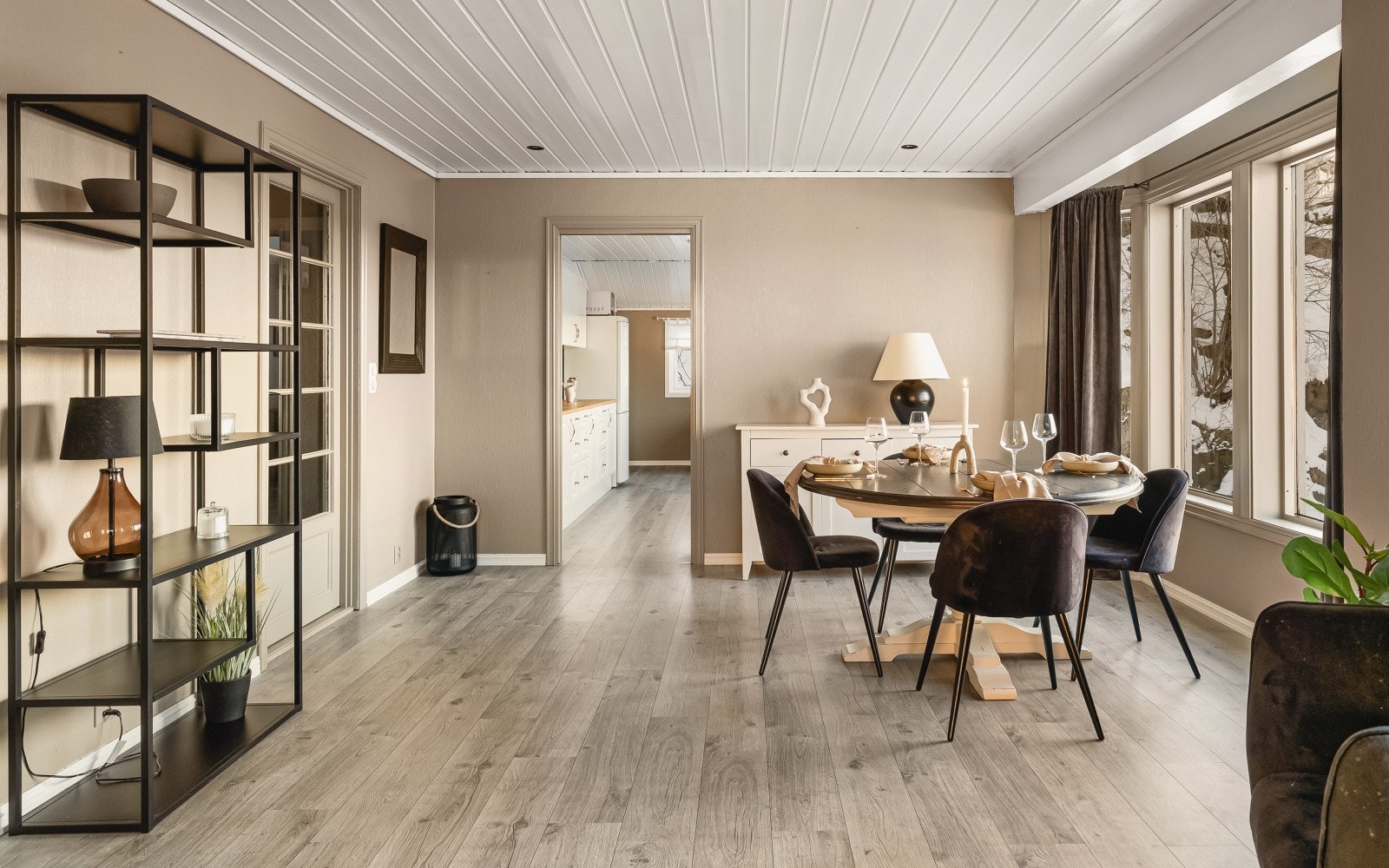 Gulvet er belagt med laminat, noe som gir en helhetlig stil og går igjen i flere oppholdsrom. Galleribilde