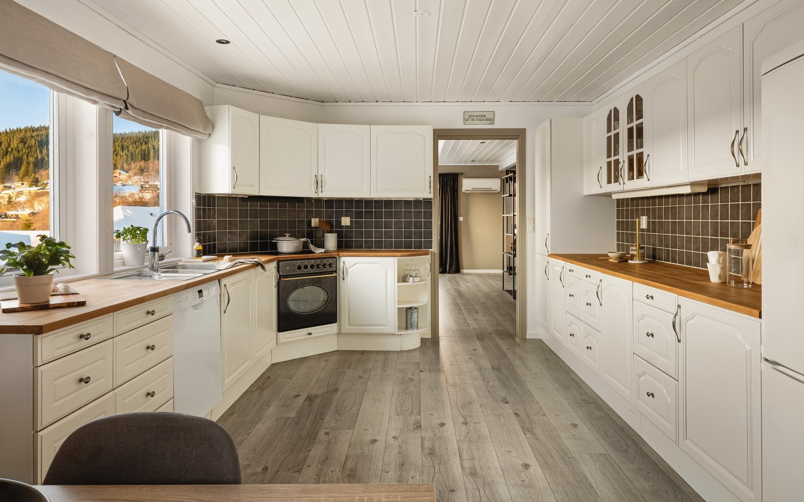Kjøkkenet (20,8 m²) er et lyst og funksjonelt rom med innredning fra Sigdal - profilerte fronter og vitrineskap i furu, benkeplate i heltre og nedfelt stålvask med skyllekum. Galleribilde