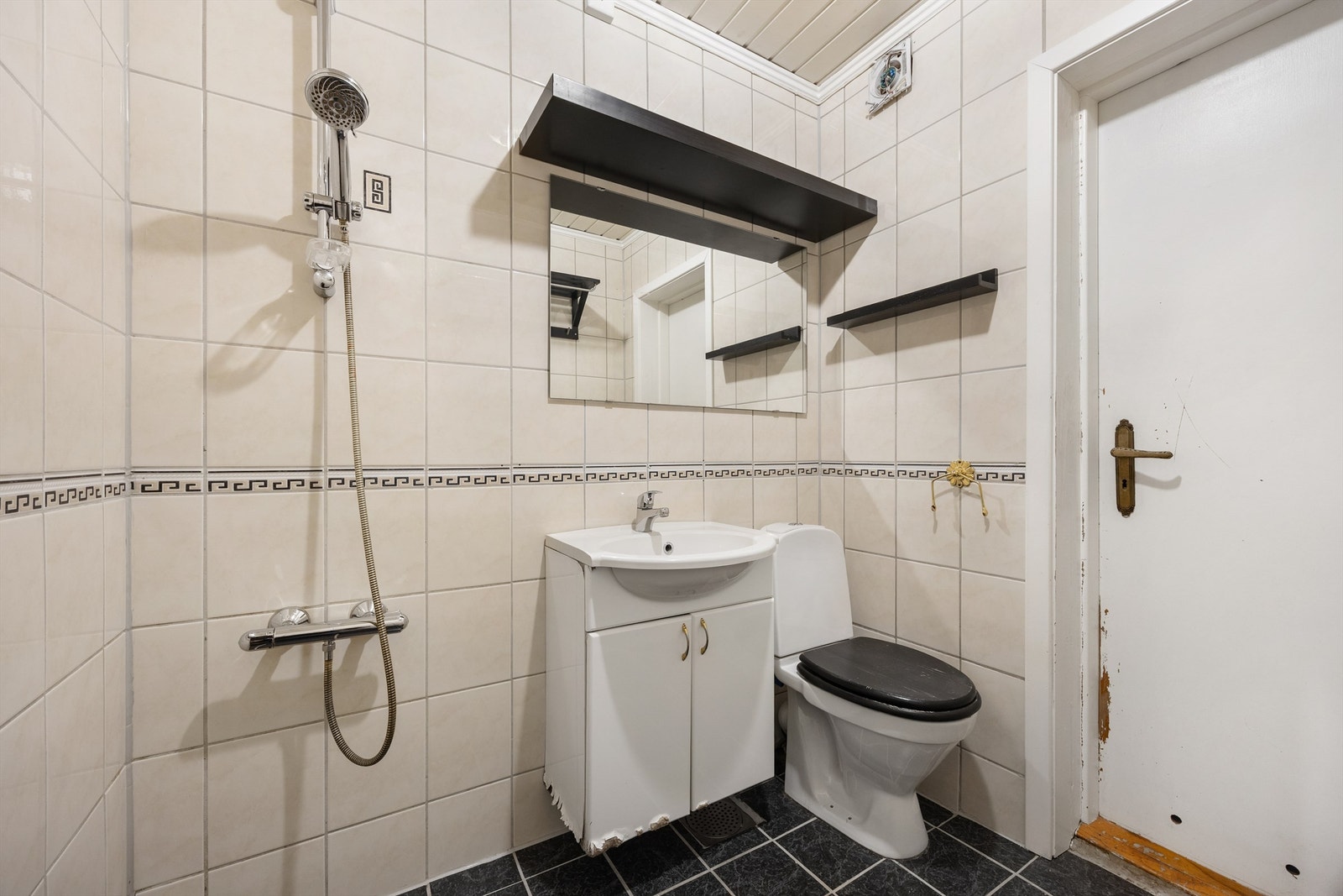 Badet i 2.etg har vegghengt skap og speil, frittstående toalett og dusj på fliser Galleribilde