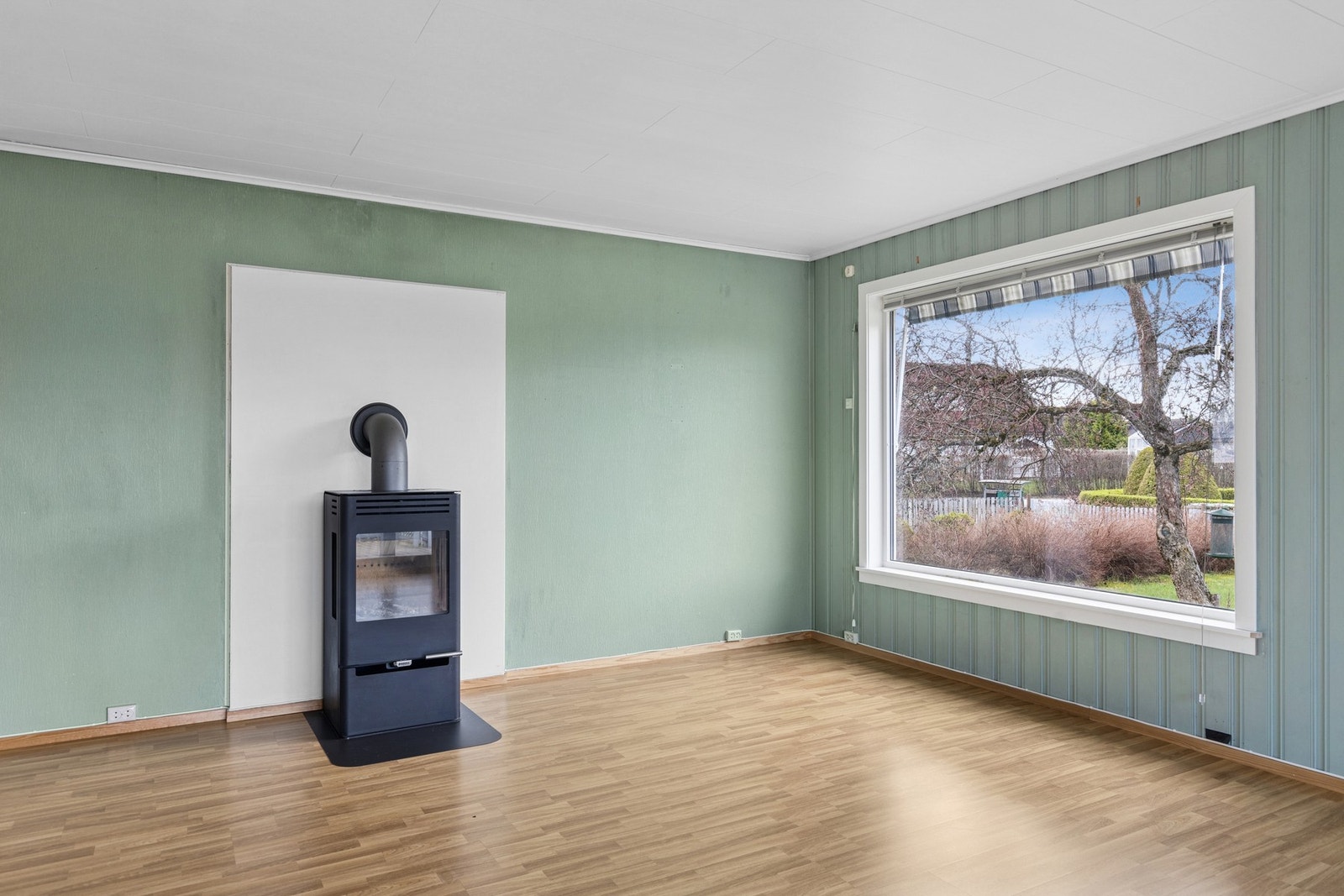 Stuen har også en hyggelig peisovn og montert varmepumpe. Galleribilde