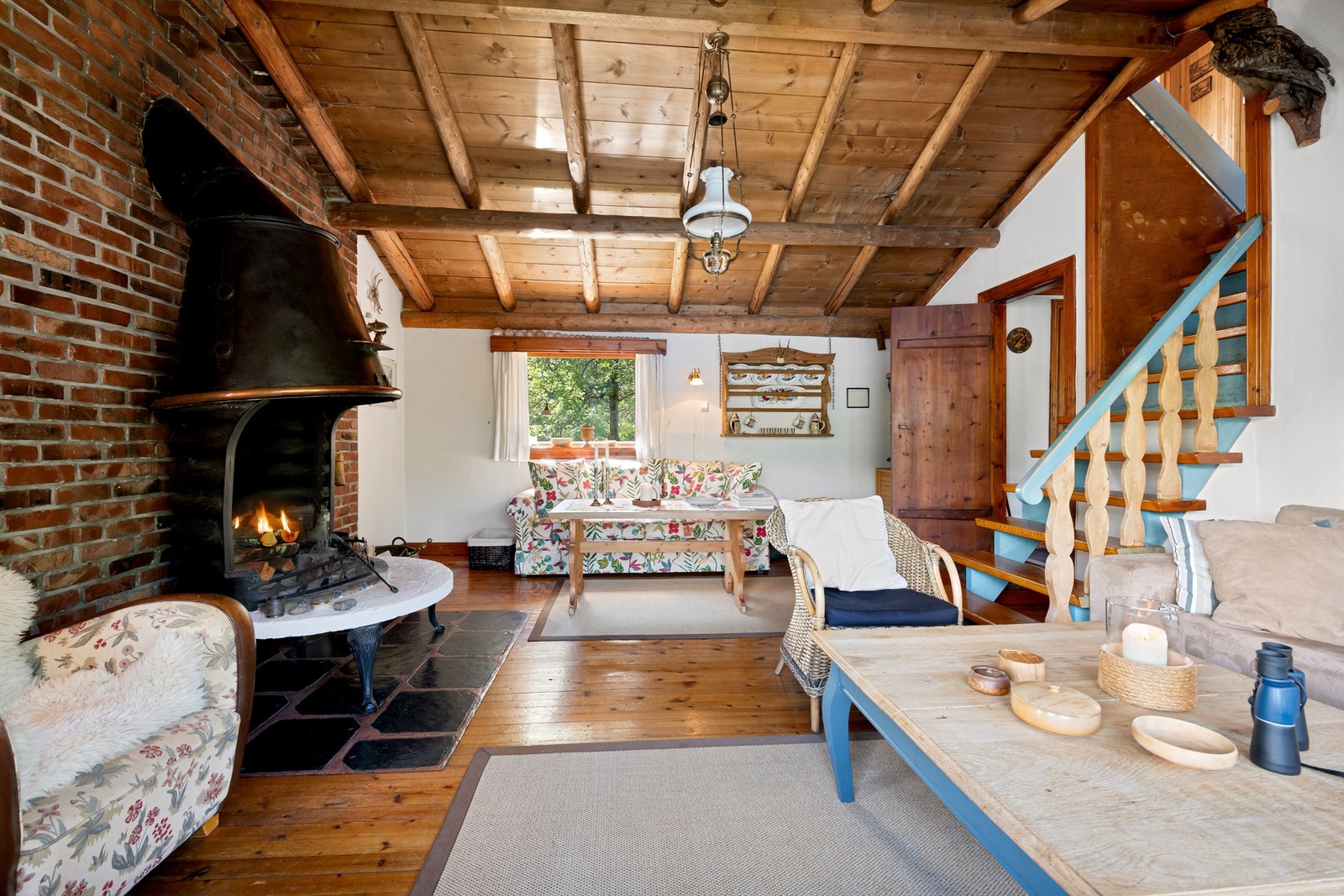 Det er åpen peis i stuen som gir en lun og hyggelig atmosfære. Trapp fra stue til soverom i loftsetasjen Galleribilde