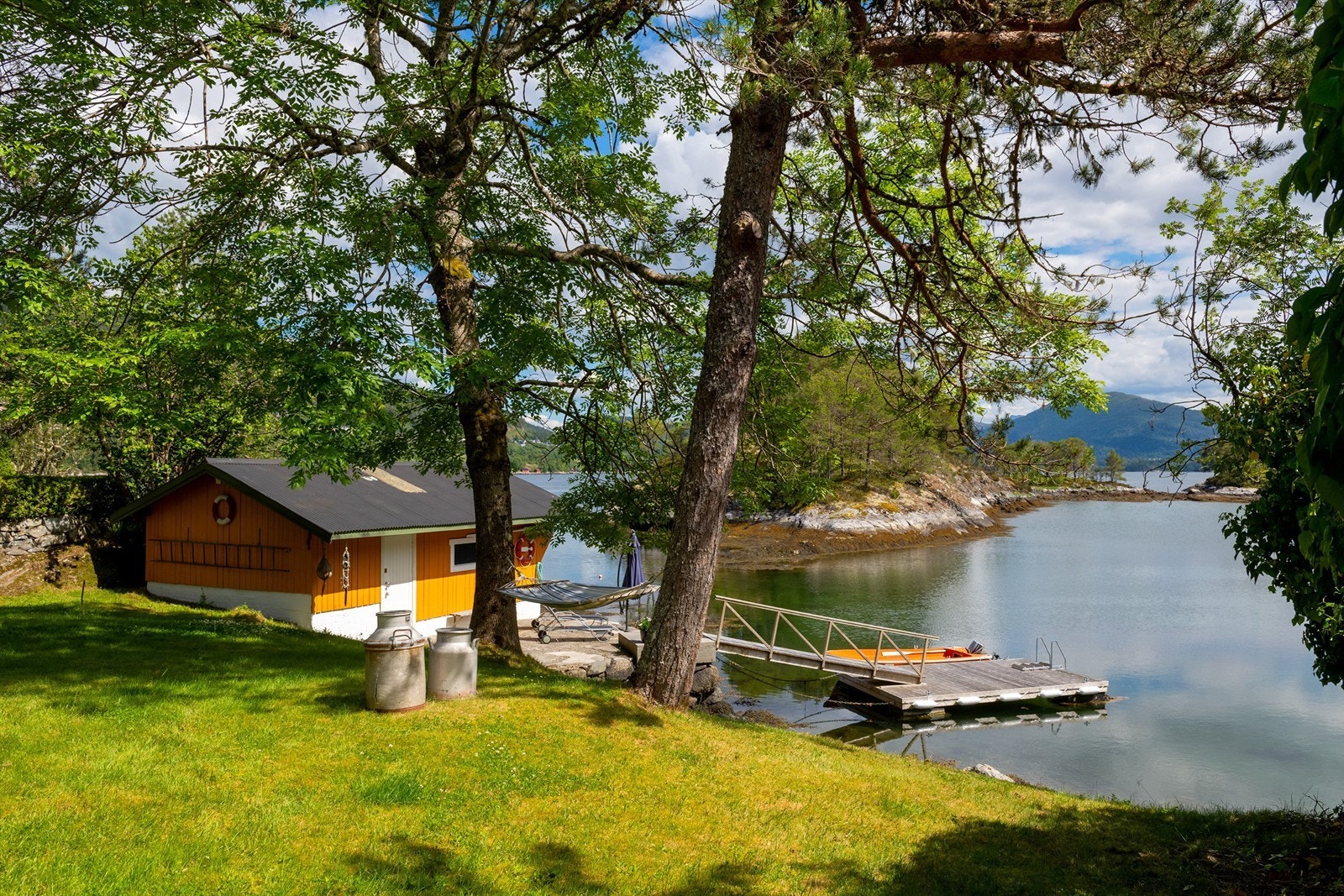 Naust og flytebrygge sett fra hagen Galleribilde