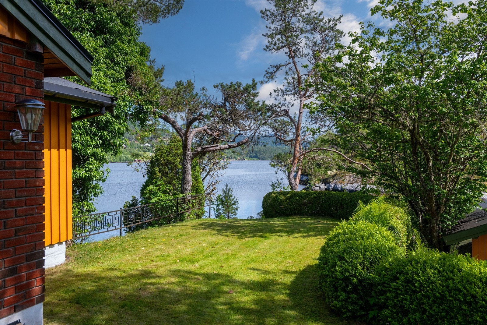 Deler av hagen mot øst med plenareal og noe hekkbeplanting Galleribilde