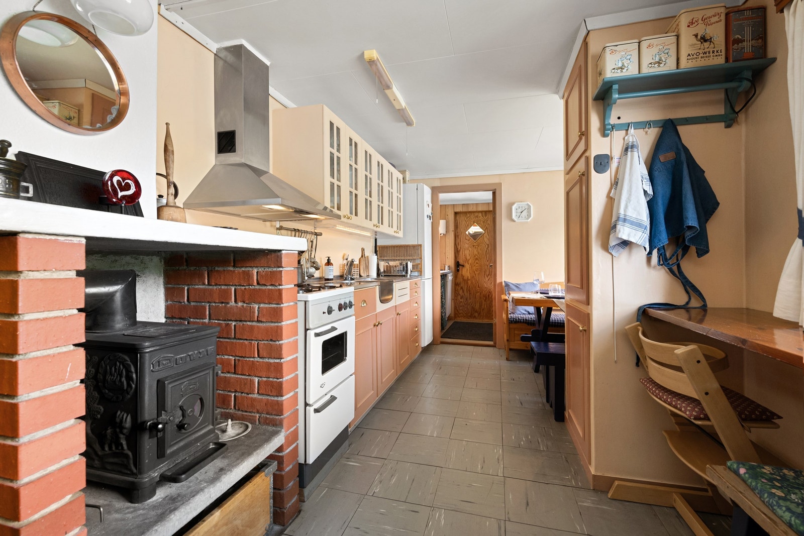 Frittstående gasskomfyr og kjøl/fryseskap på kjøkkenet. Oppvaskmaskin plassert til tilhørende vaskerom/grovkjøkken Galleribilde