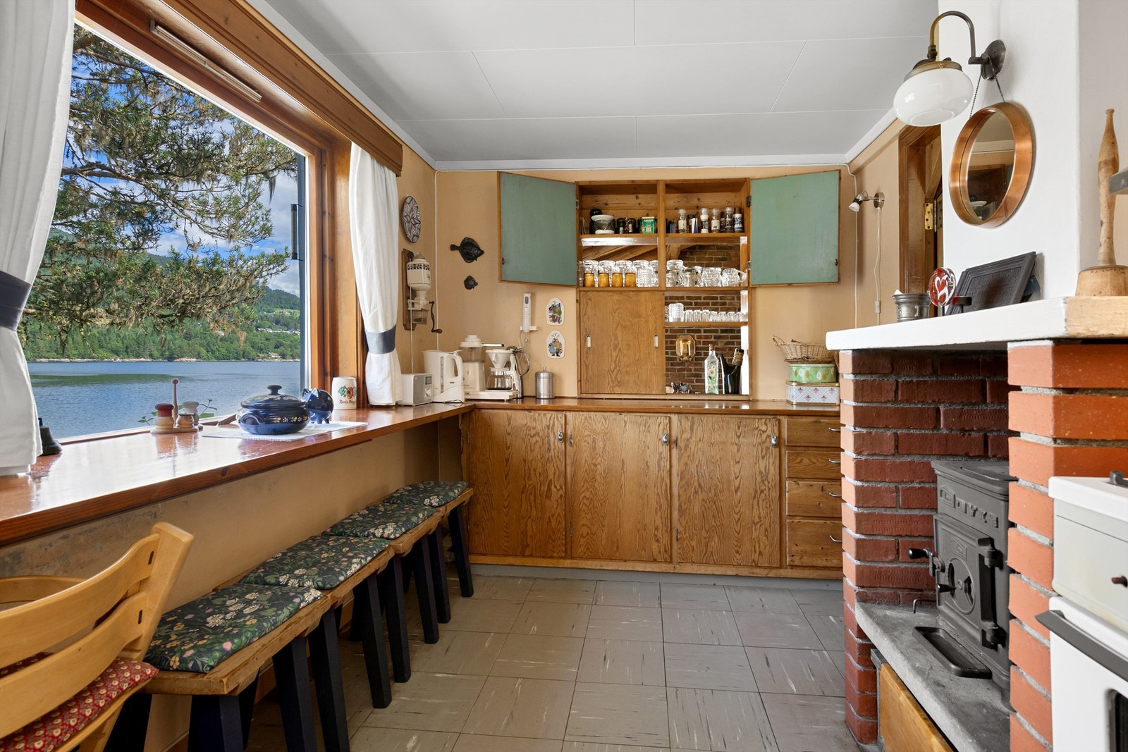 Kjøkken fra byggeår med innredning. Flott utsikt også fra kjøkkenet. Det er vedovn på kjøkkenet. Galleribilde