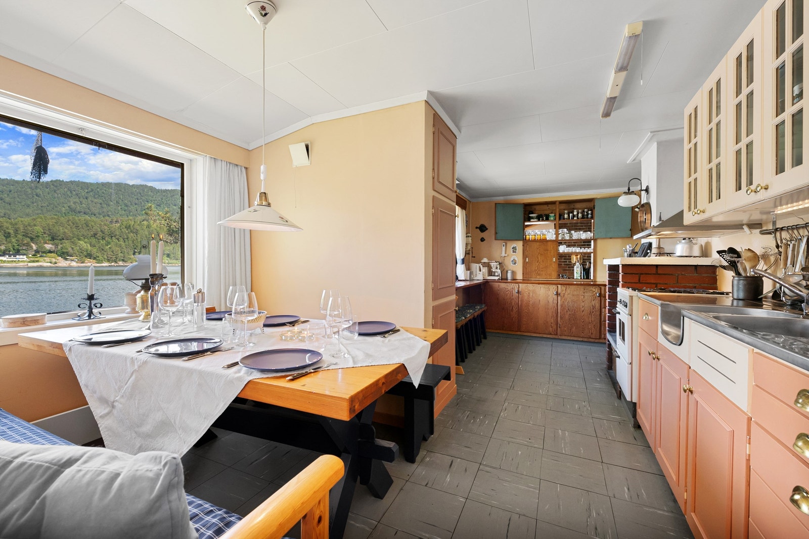 Det er god plass til spisebord på kjøkkenet som er plassert ved vindu med flott utsikt over fjorden Galleribilde