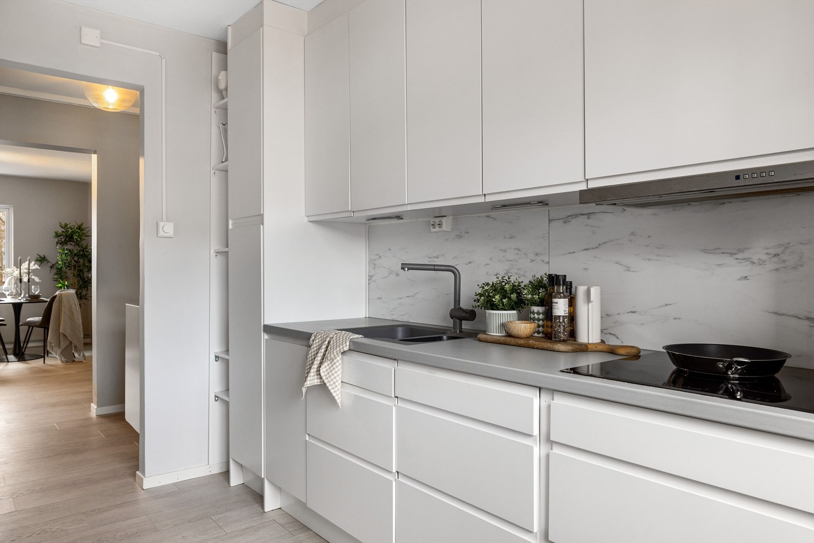 Stilrent og moderne Epoq-kjøkken fra 2018 med god skap- og benkeplass. Innredningen har hvite glatte fronter og laminert benkeplate med planlimt oppvaskkum. Galleribilde