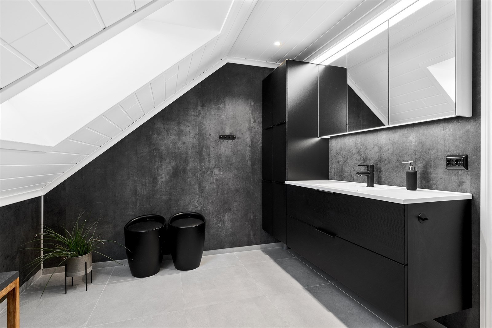 Badet er av meget god størrelse og har fliser med varmekabler på gulv, stor baderomsinnredning med speilskap over, samt toalett, badekar og dusjkabinett med regndusj. Galleribilde