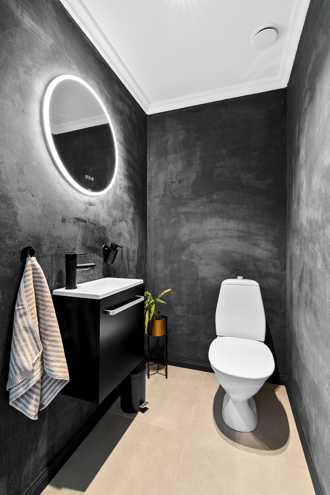 Du finner et praktisk toalettrom like ved entreen og hallen. Det har fliser på gulv, samt nyere baderomsinnredning med speil over. Galleribilde