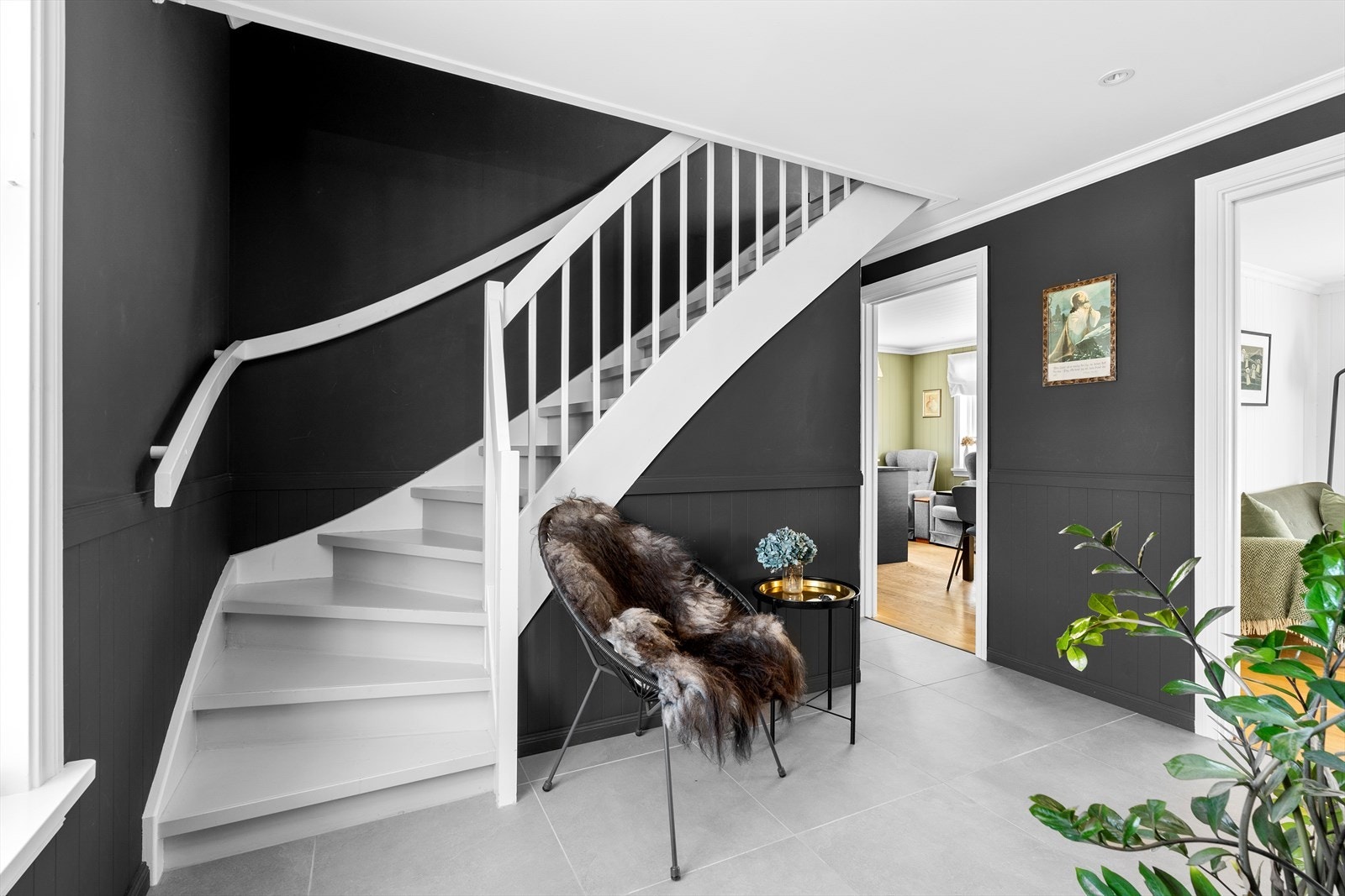 Videre inn finner du en romslig hall med fliser på gulvet. Himlingen i de fleste rom i 1.etg. er pusset opp, hvor det er satt inn praktiske downlights som gir god belysning om ønskelig. Galleribilde