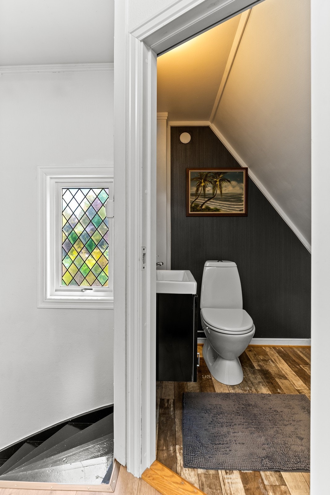 Separat toalettrom i 2. etasje utstyrt med gulvmontert wc og mindre skapinnredning med servant Galleribilde