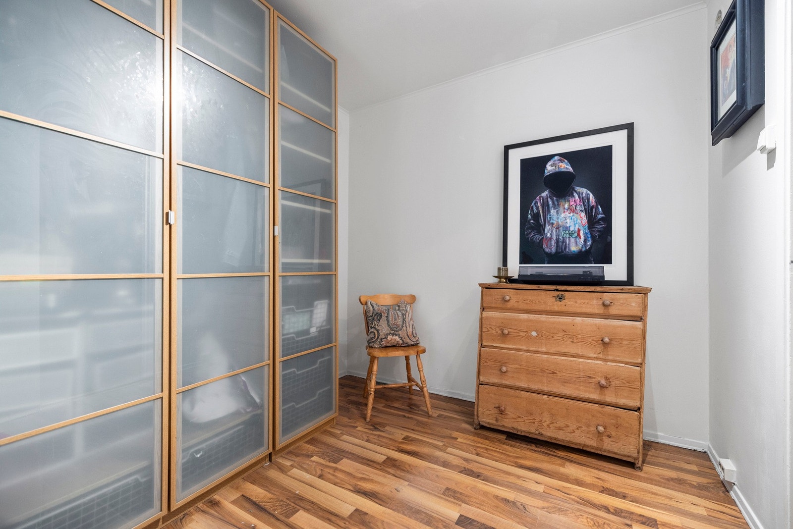 Boden i boligen er innredet med stort garderobeskap, kontorpult og kommode Galleribilde