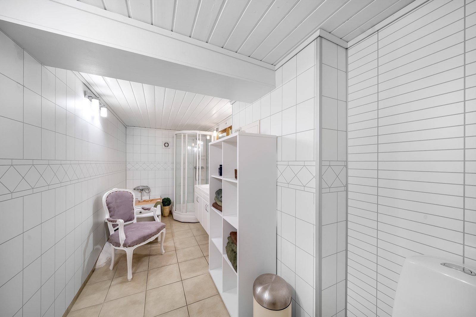 Pent bad med fliser med varmekabler på gulv og baderomsplater på vegger. Badet er innredet med baderomrinnredning, toalett, dusjkabinett og badekar. Galleribilde