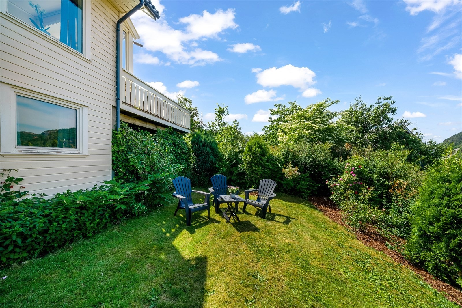 Nedre del av tomta er belagt med gress og er pent beplantet. Galleribilde