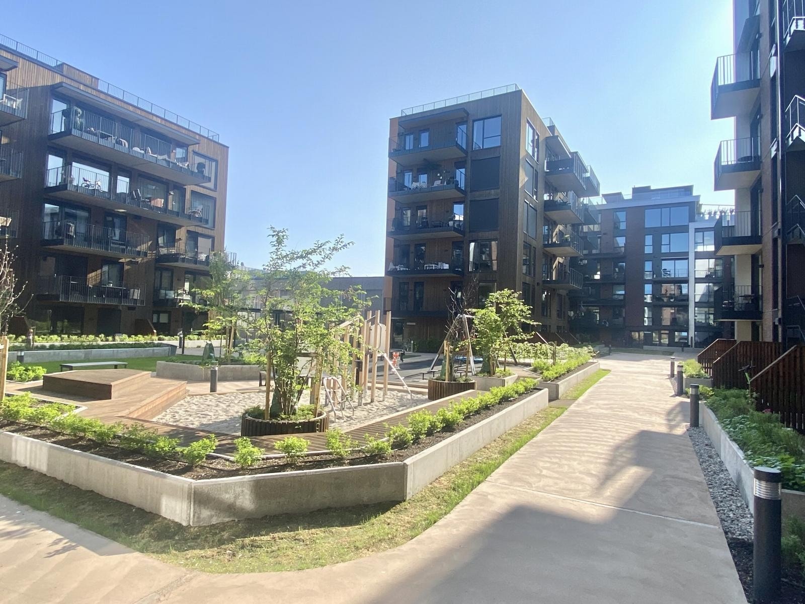 Atriumet er et attraktivt og levende areal mellom byggene - pent opparbeidet med gangveier, plener, plantefelt og lekeplass Galleribilde