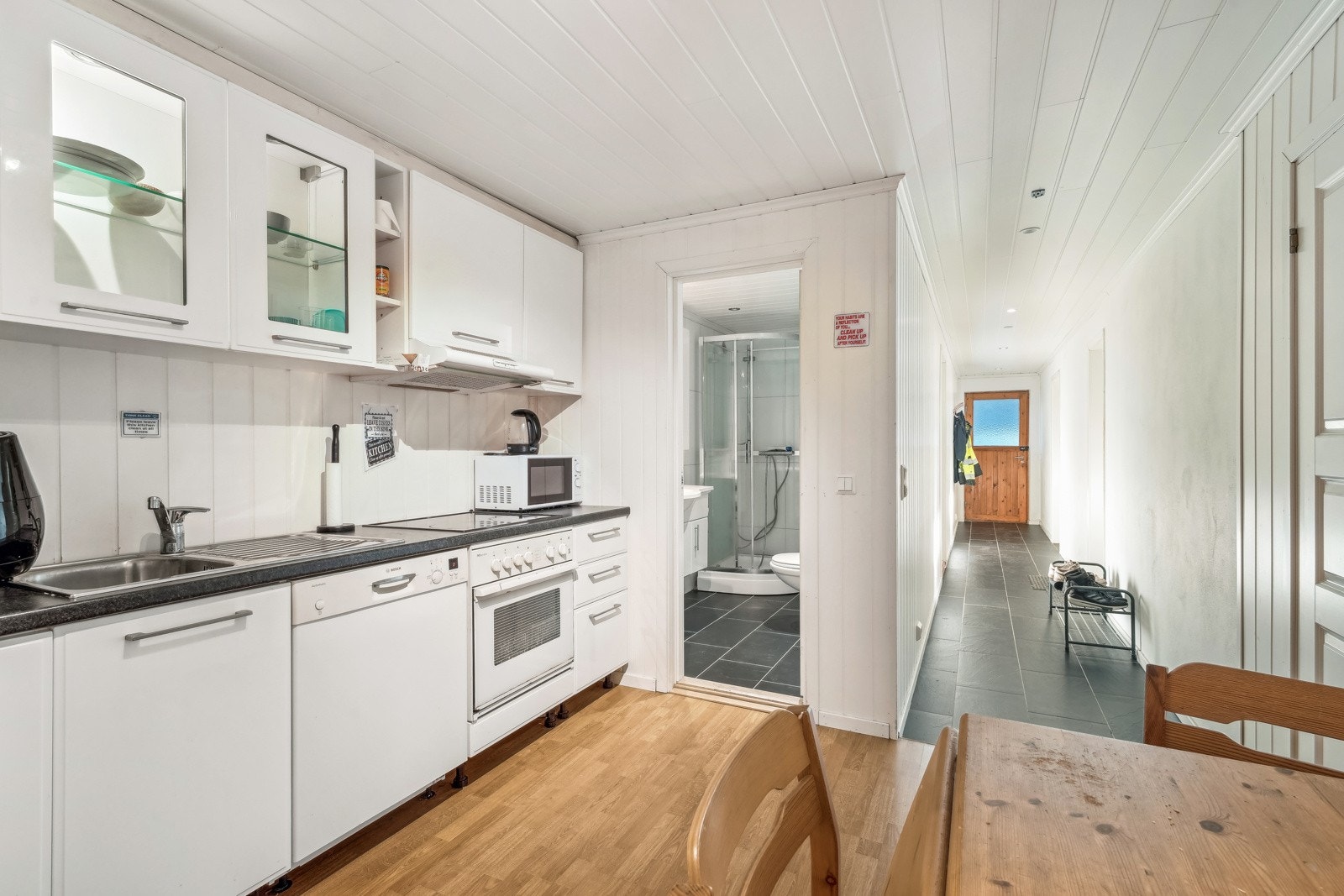 Kjøkkenet i underetasjen har hvite profilerte fronter og laminat benkeplate. Hvitevarene medfølger i handelen. Galleribilde