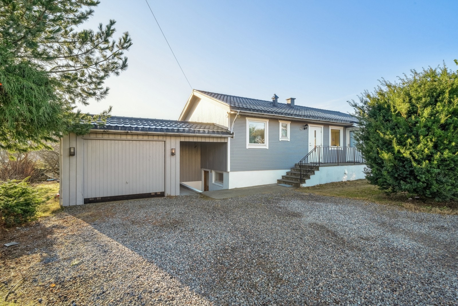 På nordsiden av boligen er det garasje og stor singlet gårdsplass med god plass til parkering. Galleribilde