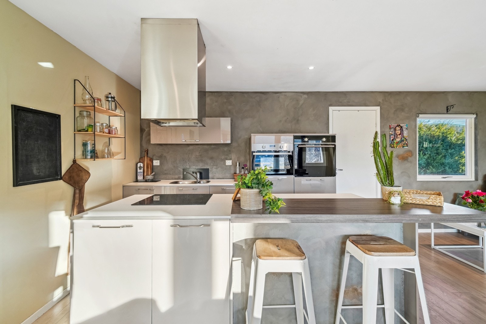 Innredning med grå glatte fronter, øy med laminat benkeplate og barbenkeplate. Galleribilde