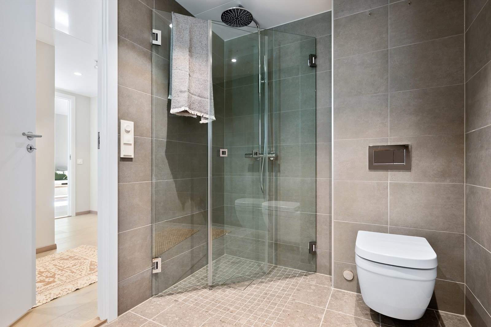 Dusjhjørne med regnfallsdusj samt veggfestet wc med innebygget sisterne Galleribilde