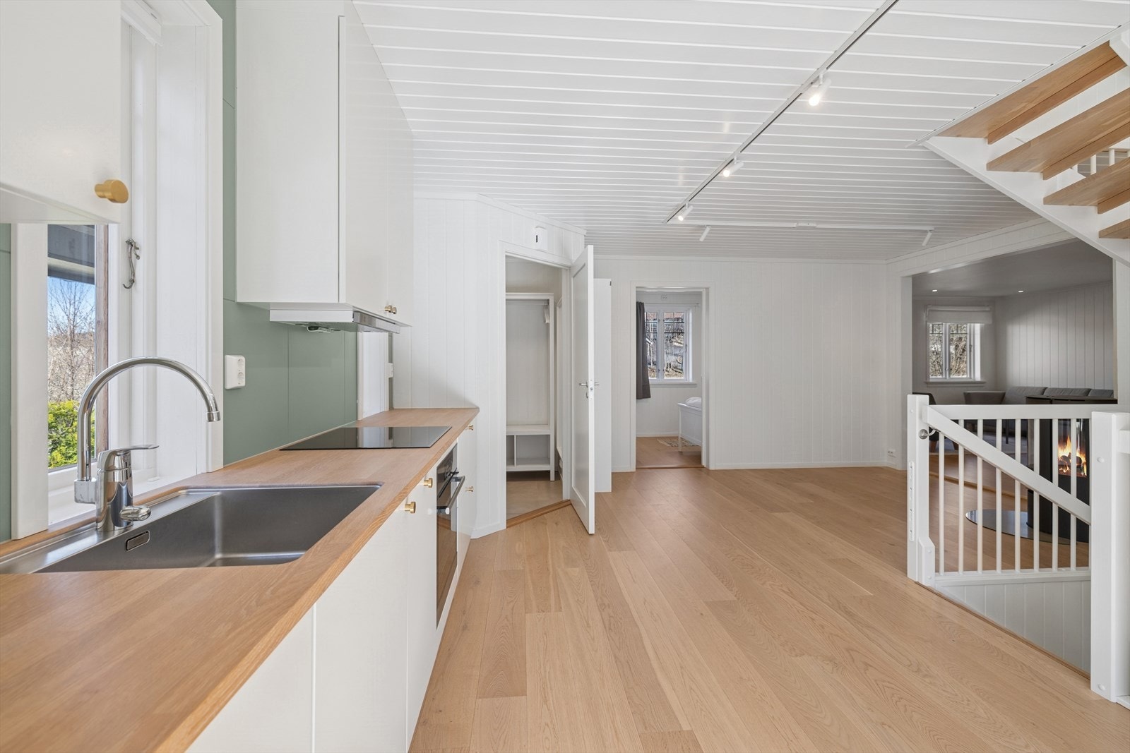 Kjøkken/allrom med trapp til kjeller og 2. etg. Entrè, stue og soverom sees i bakgrunnen. Galleribilde