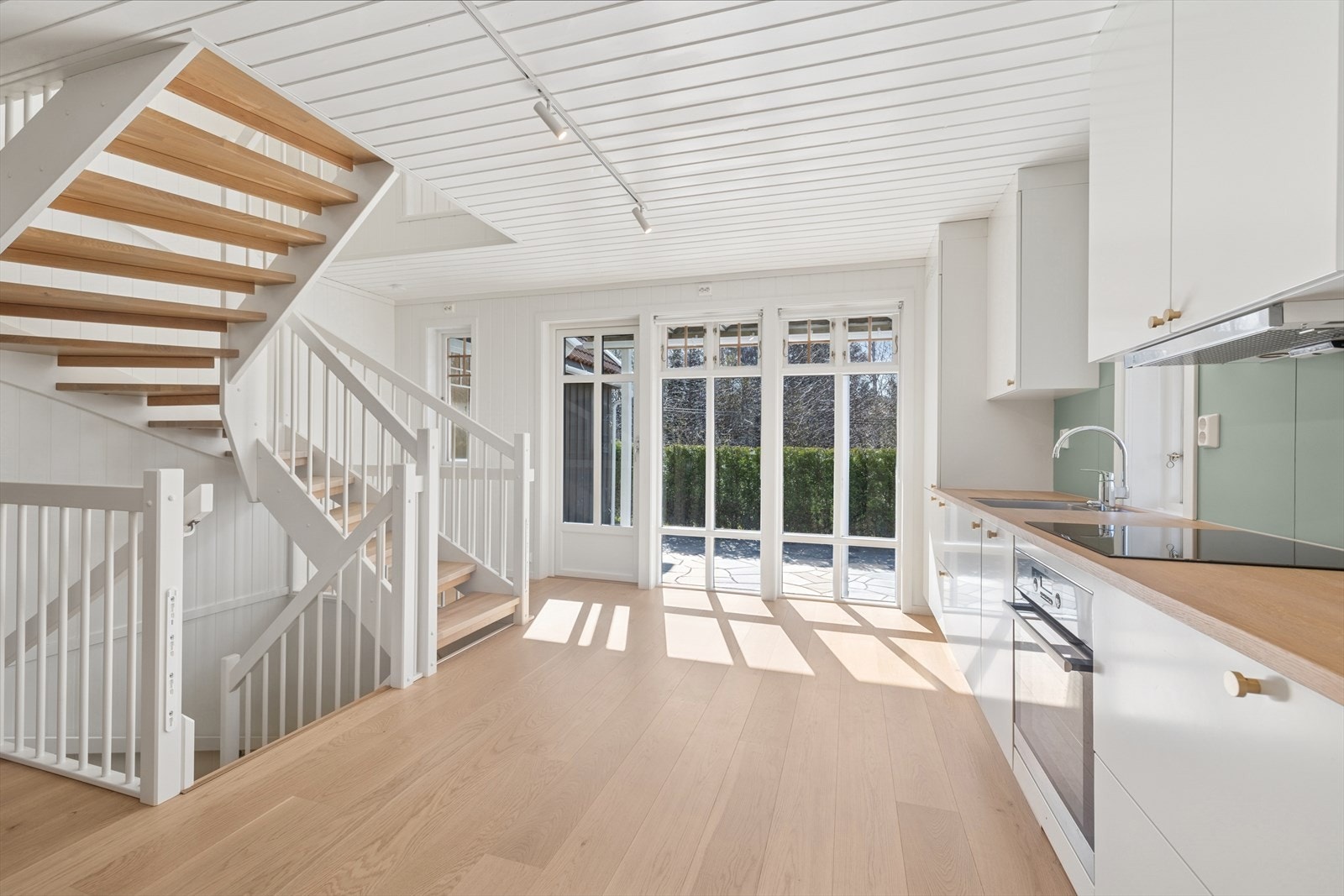 Kjøkken/allrom i utleiedelen med store vindusflater og utgang til usjenert uteplass. Galleribilde