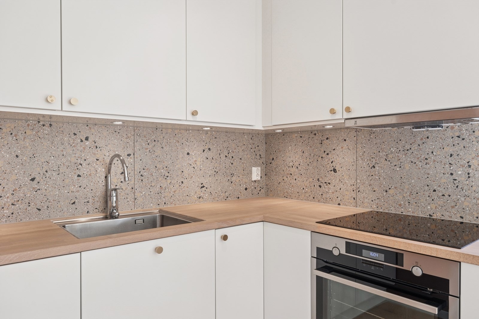 Flotte detaljer som heltre eik benkeplater, underlimt vask og fliser over benken. Galleribilde