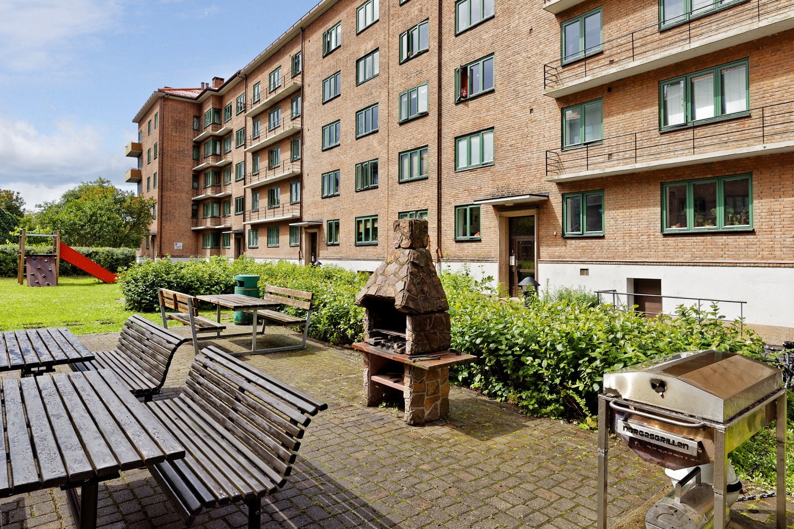 Særdeles pent opparbeidet fellestomt med grøntarealer, busker, trær, beplantning, asfalterte internveier og hellelagte områder Galleribilde