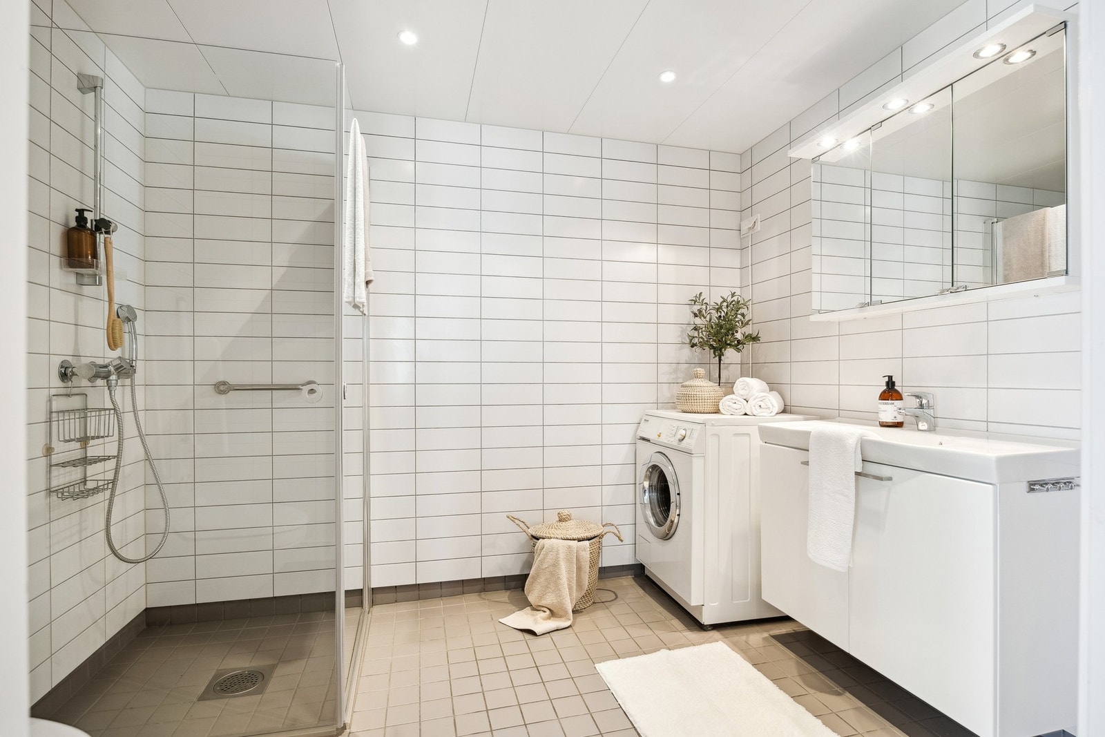 Stort bad med gulvvarme, stilig dusjhjørne med glassdører og opplegg for vaskemaskin. Det er også Vegghengt handicaphåndtak. Galleribilde