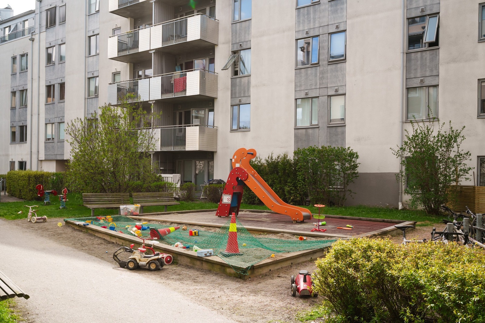 Her finner man en fredelig og familievennlig bakgård med lekeplass og sittebenker Galleribilde