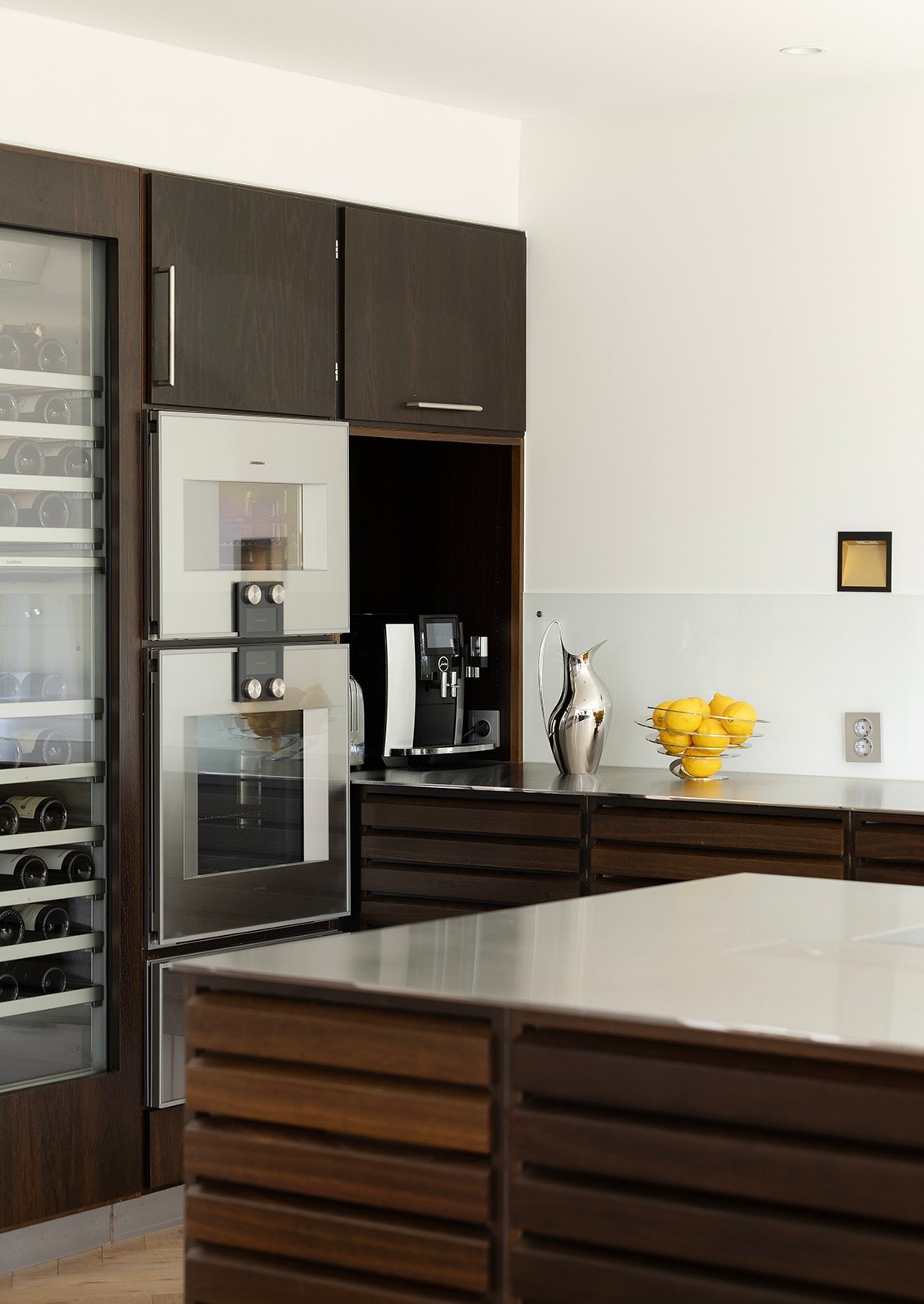 Hvitevarer fra Gaggenau 400 serie - blant annet fryseskap med ismaskin, vinskap, dampovn med vanntilkobling og stekeovn med roterende grill. 700 mm (ekstra dyp) benkeplate i 8 mm børstet edel stål med helsveiset nedfelt vaskekum. Galleribilde