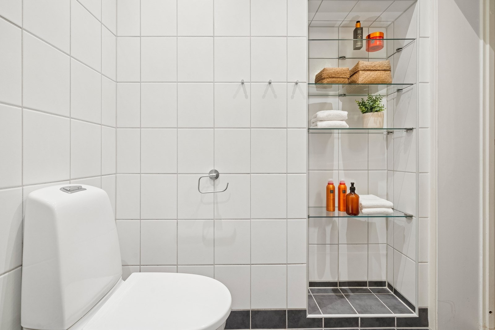 Badet er også innredet med et gulvfestet toalett samt hyller til oppbevaring av toalettsaker og diverse. Galleribilde