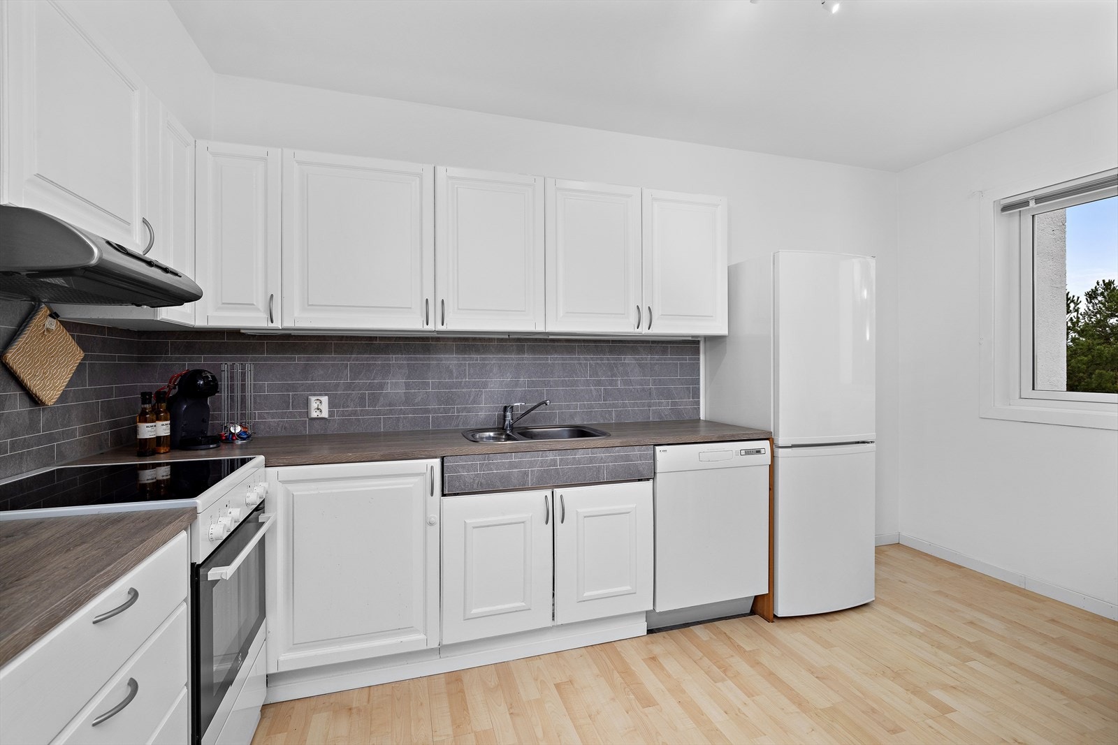 Romslig kjøkken med plass til spisebord og stoler. Galleribilde