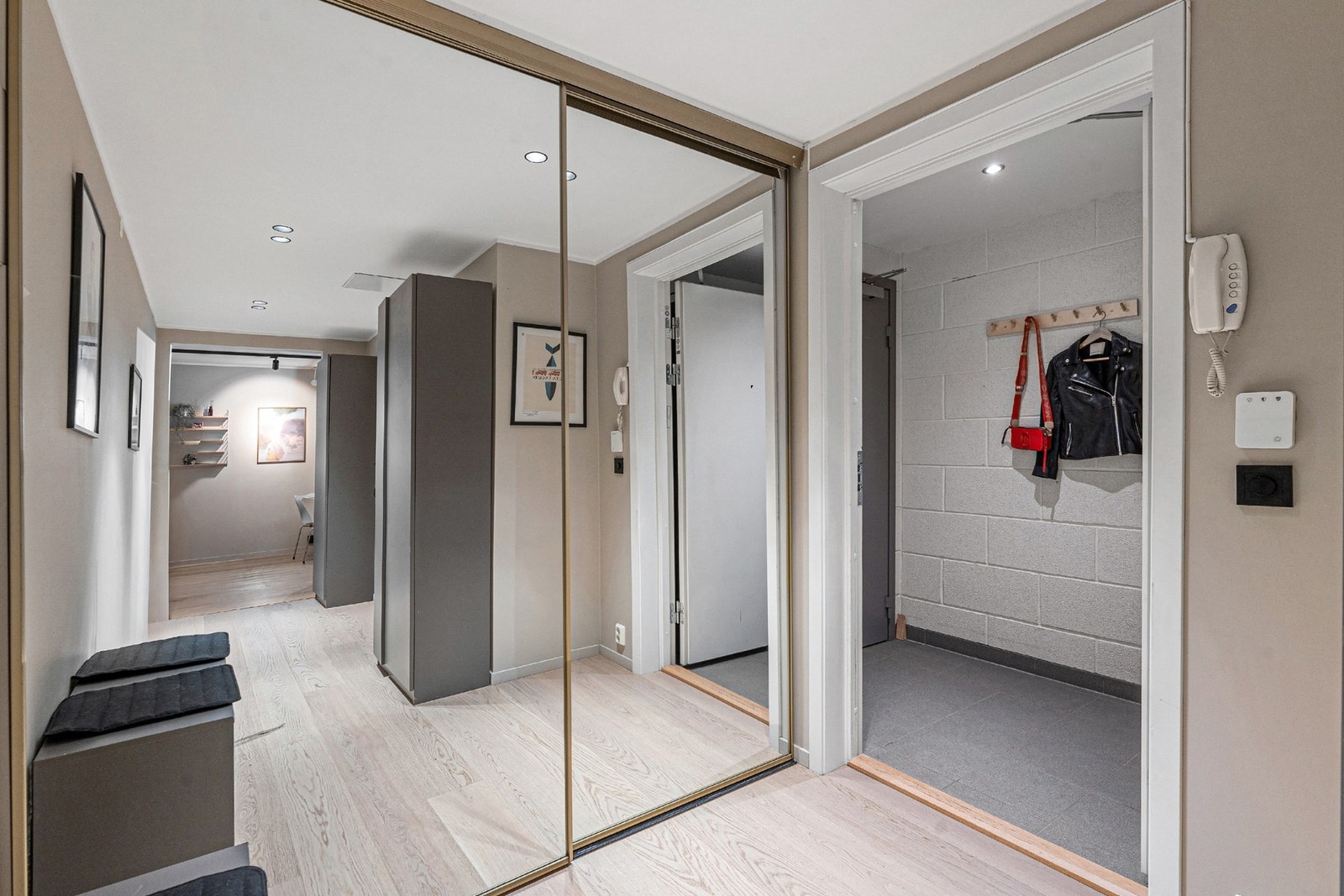 Romslig gang med svært gode oppbevaringsmuligheter i stor skyvedørsgarderobe med speilfront. Galleribilde