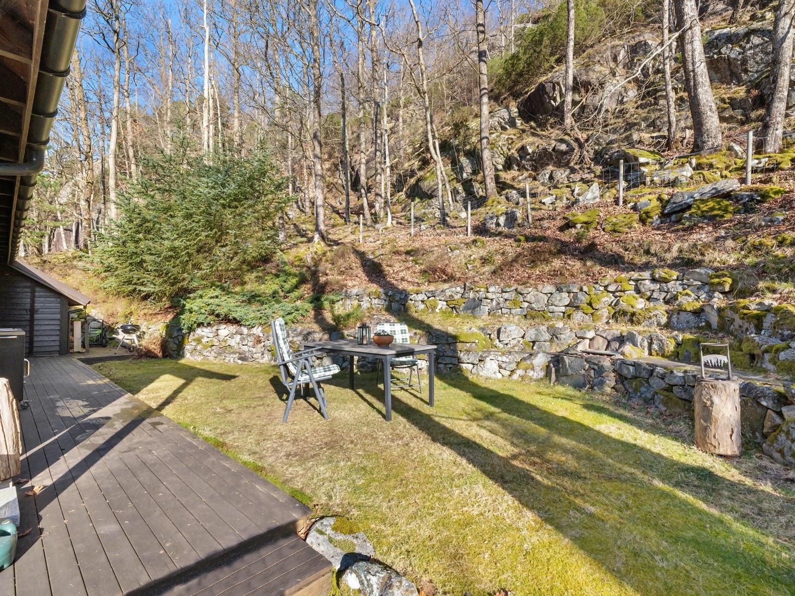 Ved inngangspartiet er uteområdet pent opparbeidet med plen og utvendig bod Galleribilde
