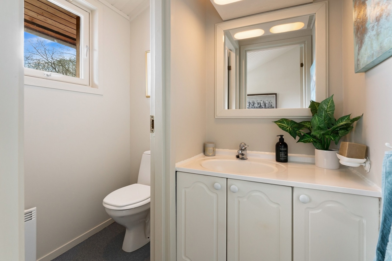 Separat toalettrom med servant, underskap og gulvmontert toalett. Galleribilde