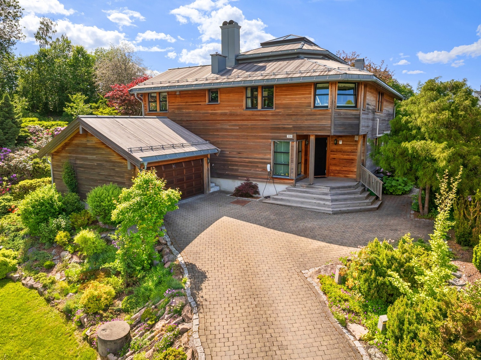 En unik, arkitekttegnet enebolig over tre plan omkranset av parklignende hage. Galleribilde