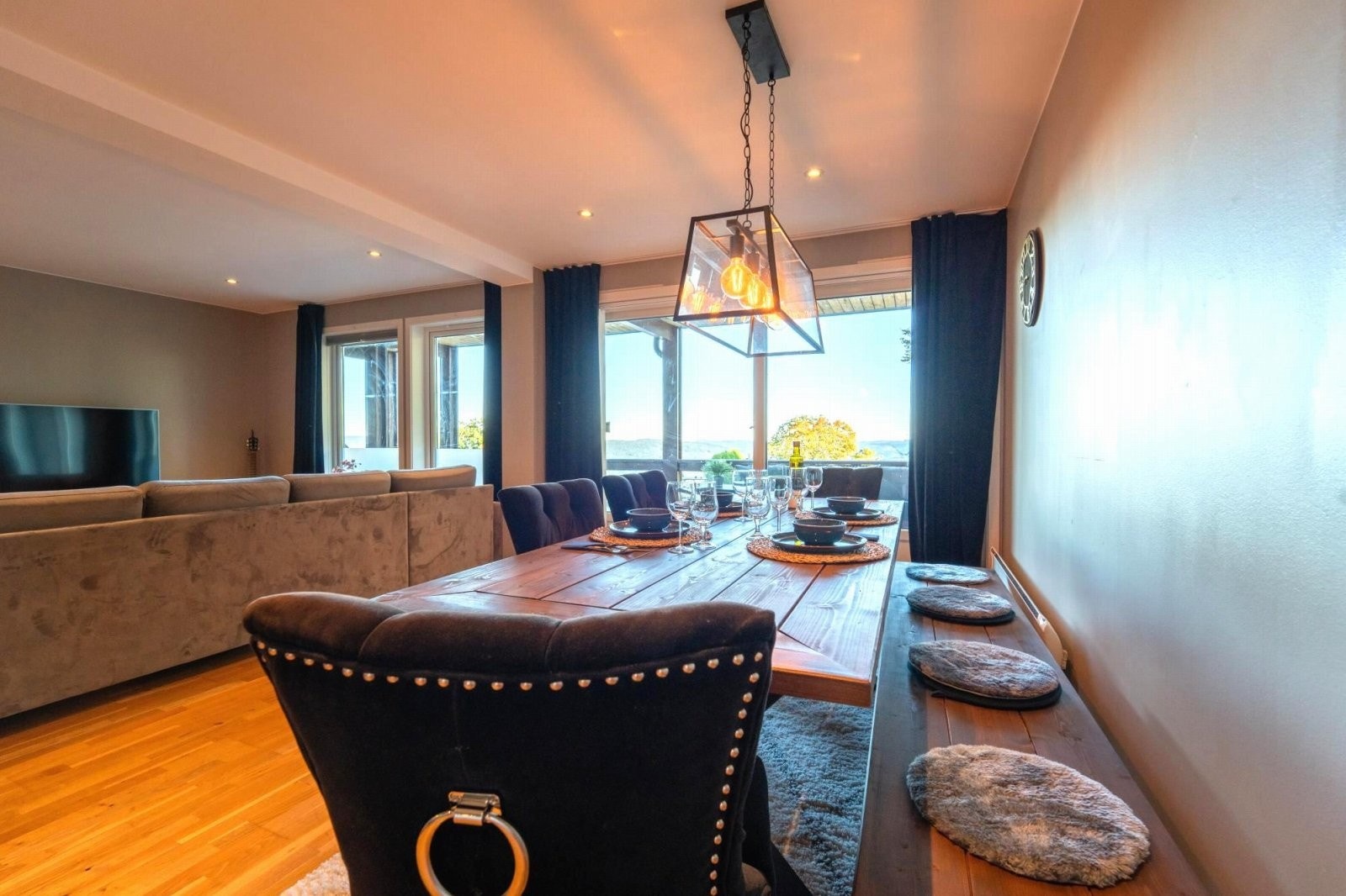 Store vinduer i stua som skaper god og varm romfølelse Galleribilde