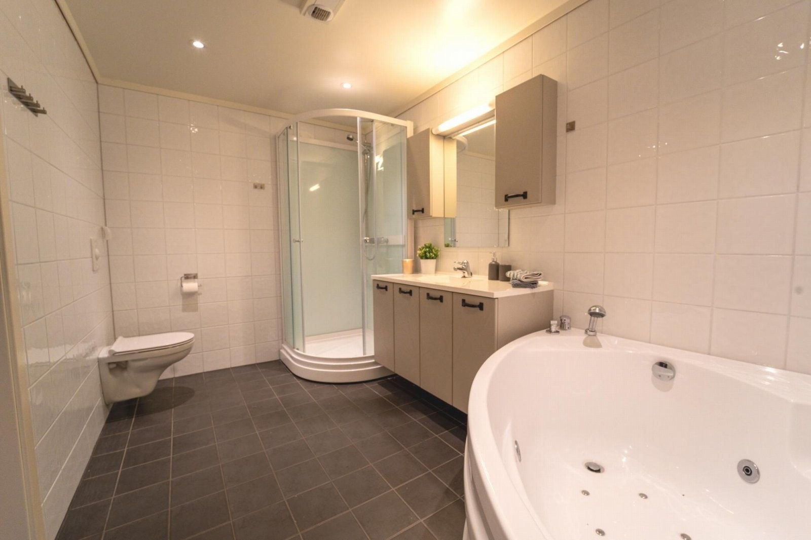 Romslig bad med både hjørneboblebad og dusjkabinett Galleribilde