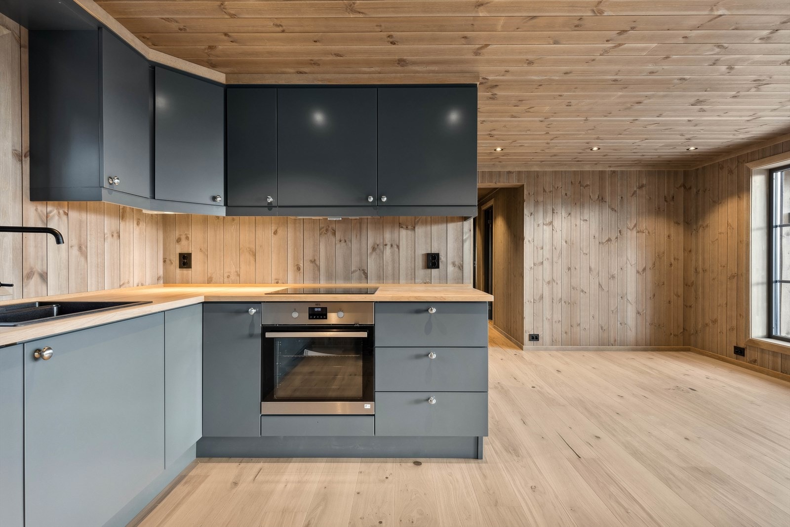 Lekker gråmalt kjøkkeninnredning, type Tidløs fra Nedre Eggedal Hyttemøbel. Benkeplate av eik. Galleribilde