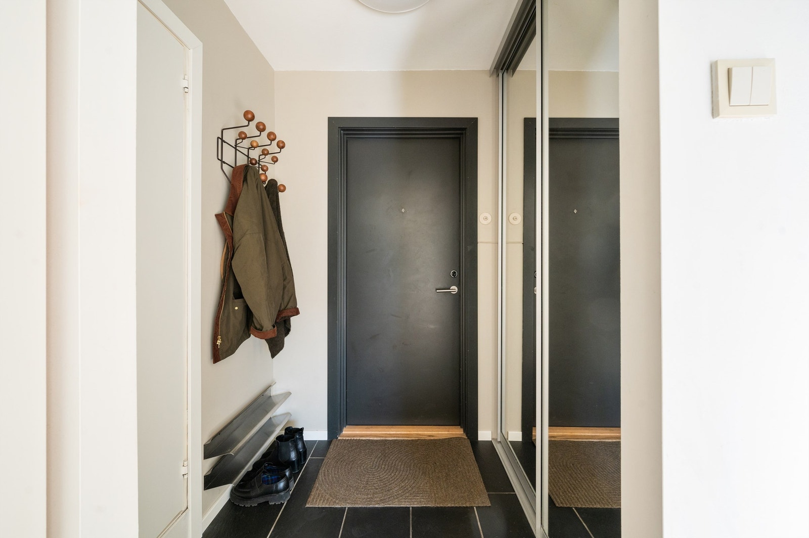 Romslig entré med garderobe og flislagt gulv Galleribilde
