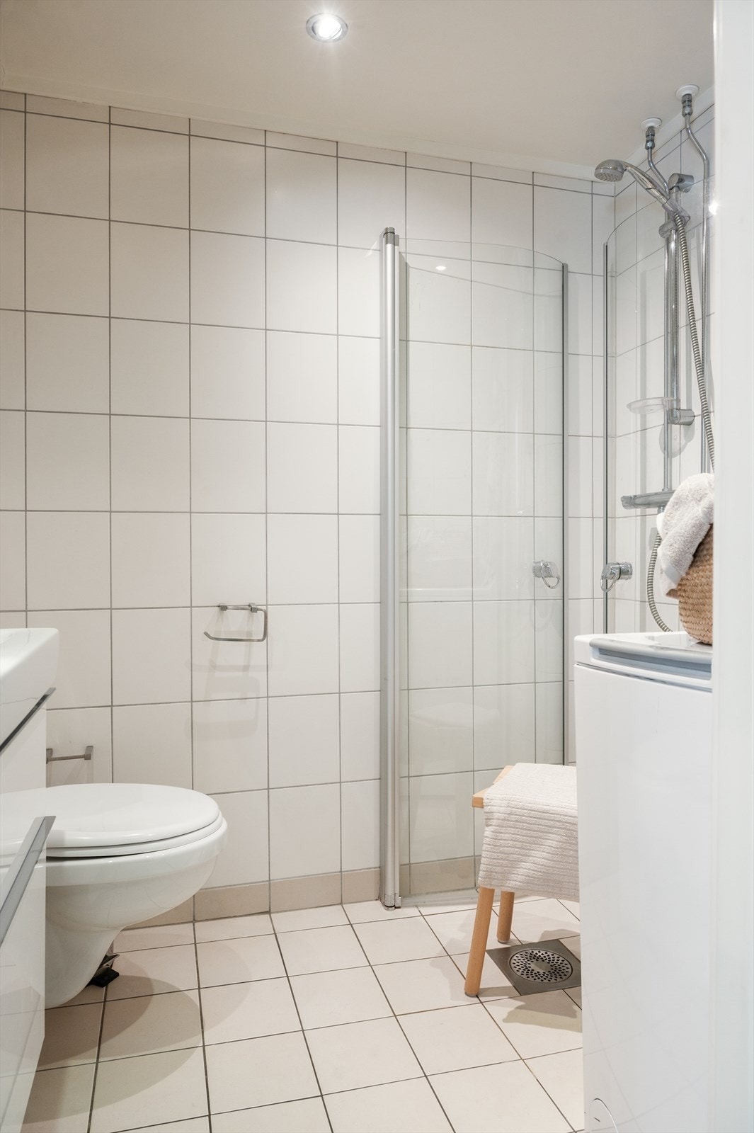 Badet har varmekabler i gulv, downlights i tak og opplegg for vaskemaskin Galleribilde