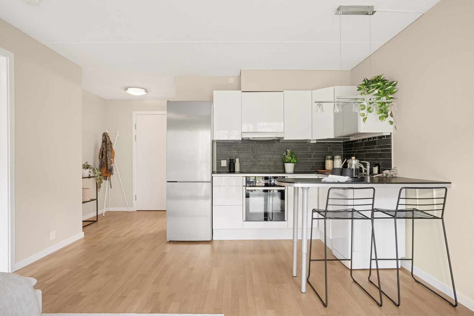 Det er fliser på vegg over benkeplaten og belysning under overskap. Innredningen er utstyrt med integrert stekeovn og platetopp, og opplegg for oppvaskmaskin. Galleribilde