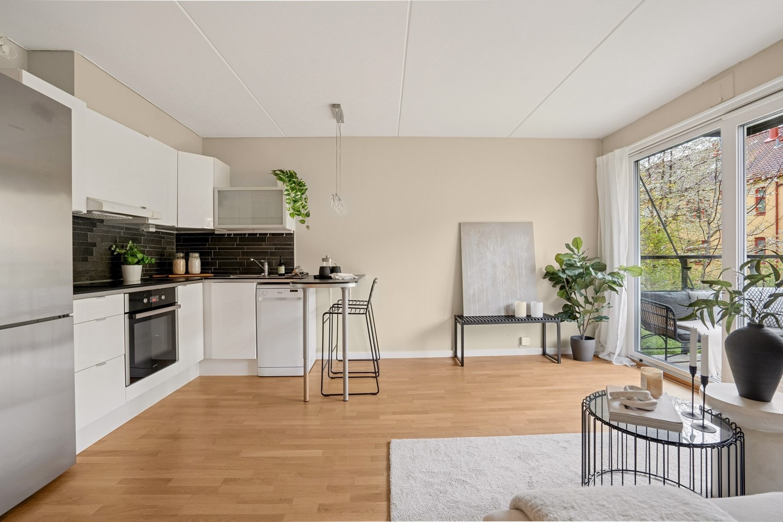 Kjøkkeninnredning har glatte fronter og en frostet glassfront i overskap og benkeplate i laminat. Galleribilde