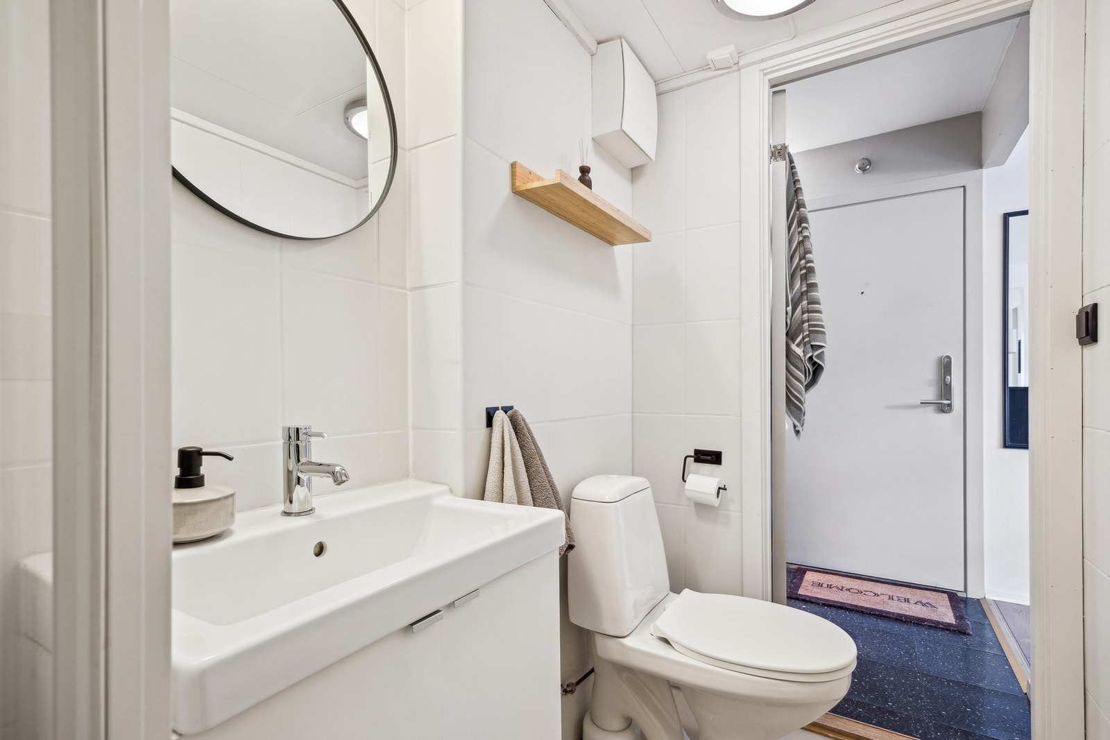 Badet er utstyrt med dusjkabinett, servant, servantskap og toalett. Galleribilde