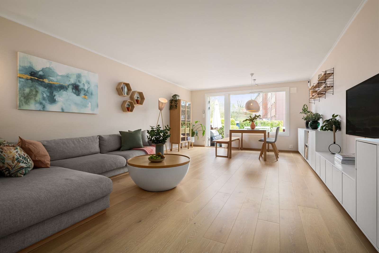 Stuen har rikelig med naturlig lys fra store vindusflater som vender ut mot boligens hage Galleribilde